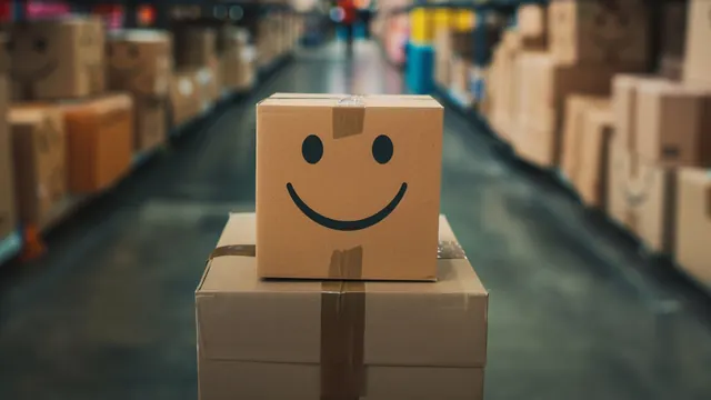 Versandkarton mit aufgemaltem Smiley in einer Lagerhalle